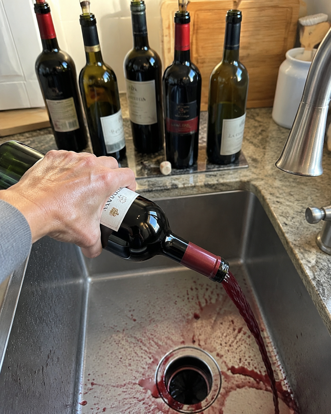 Red wine being poured down the sink
